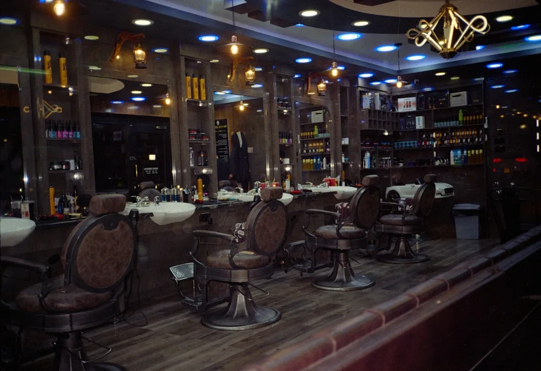 An empty barbershop interior with several chairs and mirrors.